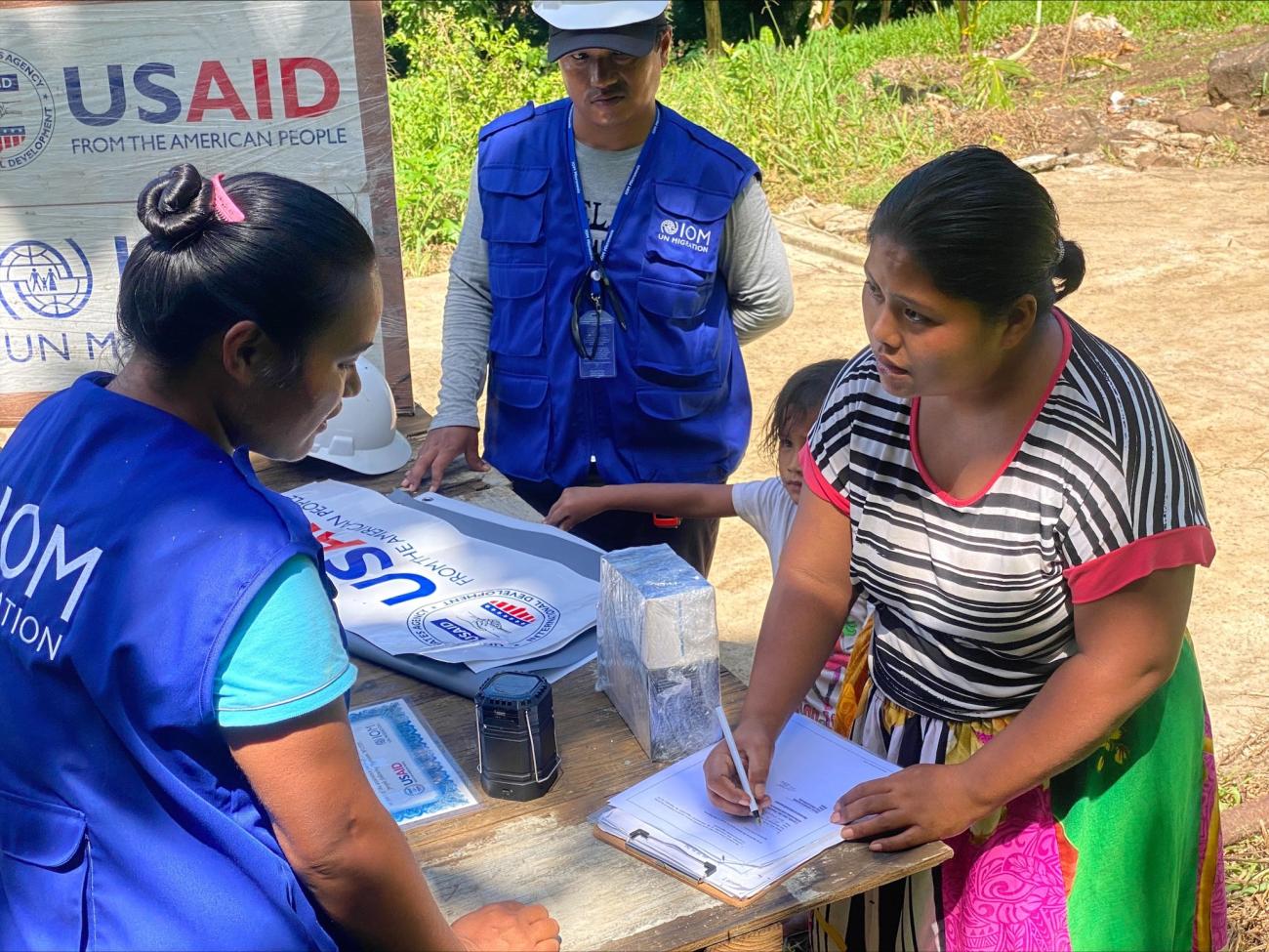 A resident in Chuuk Lagoon who lost her home to the impacts of Typhoon Wutip signs handover documents to take ownership of a newly constructed house. Photo. IOM 2022. Lee Perez