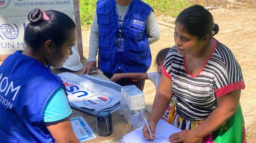 A resident in Chuuk Lagoon who lost her home to the impacts of Typhoon Wutip signs handover documents to take ownership of a newly constructed house. Photo. IOM 2022. Lee Perez